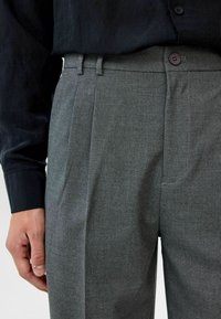 Grijze op maat gemaakte broek met een subtiele herringbone tekstuur, voorzien van een vlakke voorkant, riemlussen en een enkele knoopsluiting in de taille.