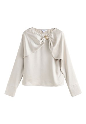 Helebeežikas beež pikkade varrukatega pluus koos volditud esiosaga ja sõlmitud detailiga, sileda tekstuuri ja laiade mansettidega.