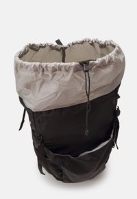 Czarny i szary plecak z materiału, zamykany na sznurek, z dwiema bocznymi kieszeniami i zaokrąglonym kształtem. Gładka faktura z lekkiego materiału.