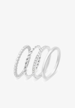Vier silberne Ringe: einer mit Perlen, einer gedreht, einer mit einer Reihe klarer Steine und ein glatter Ring. Alle sind schlank und poliert.