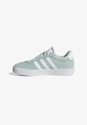 Baskets en daim vert clair avec semelle blanche et trois bandes blanches sur le côté, vues de l'extérieur.