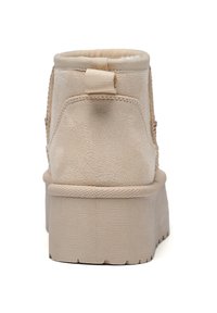 Botín beige hasta el tobillo con exterior de ante texturizado, punta redondeada y suela de plataforma gruesa. Presenta un tirador trasero para facilitar su uso.