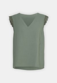 Olivgrön ärmlös topp med v-ringning i mjukt tyg, med spetsdetaljer på axlarna och en något rundad nederkant för en avslappnad passform.