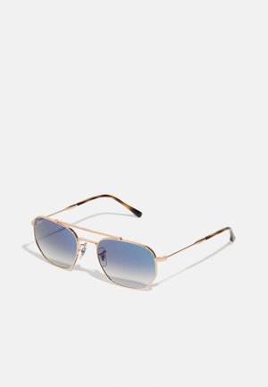 Occhiali da sole aviator metallici dorati con lenti blu sfumate. Presentano montature sottili ed allungate e punte delle tempie in marrone texturizzato.