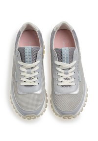 Sneaker in mesh e pelle grigio con superficie testurizzata, lacci bianchi e suola in gomma grigia chiara. Presenta un'etichetta con logo sulla linguetta.