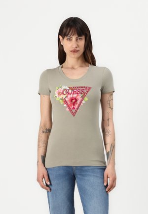 T-shirt a maniche corte, aderente, di colore verde oliva, con un design grafico floreale e triangolare in tonalità rosse e rosa.