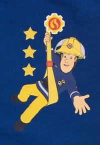Blue fabric featuring a cartoon firefighter in yellow pants and helmet. He holds a yellow rope and a gear symbol with a flame. Three yellow stars nearby.
