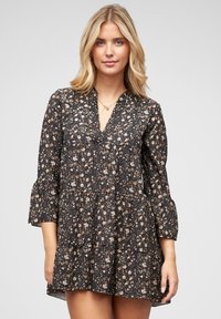 Robe noire à motifs floraux avec de longues manches évasées, encolure en V et design à volants superposés. Présente de petits motifs floraux roses et blancs sur un fond sombre.
