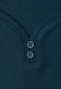 Tessuto di cotone blu navale con una finitura testurizzata, caratterizzato da un design a V e tre bottoni circolari all'collo.