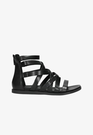 Zwarte leren sandalen met banden, met een platte zool, voorzien van meerdere overlappende banden en een achterste hielsteun. Gladde textuur, minimalistisch ontwerp.
