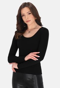 Schwarzes, geripptes Langarmoberteil mit Rundhalsausschnitt, kombiniert mit einem schwarzen Lederrock. Hat ein einfaches Design und eine figurbetonte Silhouette.