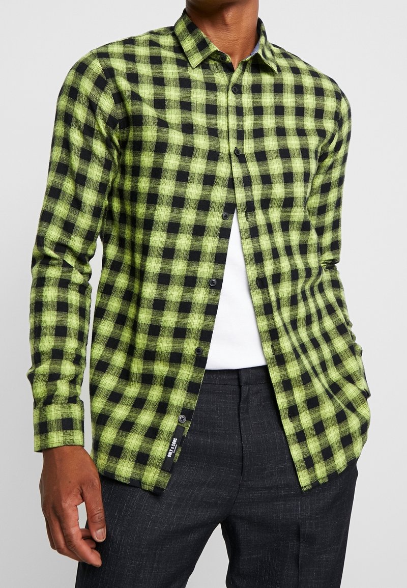 Groen en zwart geblokt, lange mouwen button-up shirt gemaakt van gestructureerde stof, met een klassieke kraag en zwarte knopen.