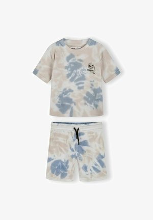 Ensemble chemise à manches courtes et short avec motif tie-dye bleu et beige, cordon noir sur le short, et petit motif graphique sur la poitrine de la chemise.