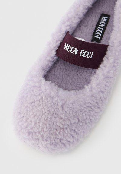 Chausson en polaire violet à forme arrondie. Comprend une bande en tissu bordeaux contrastante portant l'inscription "MOON BOOT". Texture douce, design confortable.