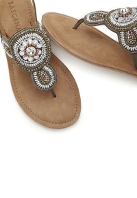 Beaded brown sandal with a textured suede sole, featuring an ornate design in silver and gold tones, with a central decorative element.