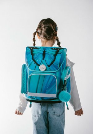 Zaino blu con un design a farfalla, spallacci regolabili, scomparti con zip e un soffice pom-pon turchese attaccato alla cerniera.