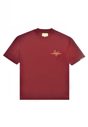 Bordo kratka majica s kratkimi rokavi in okroglim ovratnikom, z majhnim oranžnim grafičnim elementom in besedilom "PAS DE MONACO" na levem prsnem delu.