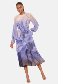 Langærmet kjole i gennemsigtigt stof med et blomstret mønster i blå og lavendel. Kjolen har en figursyet overdel og en flydende A-formet silhuet.