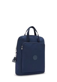 Zaino in nylon blu con due manici, chiusura con zip, tasca frontale e patch rotondo con logo. Presenta un piccolo ciondolo decorativo. Texture liscia.