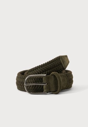 Ceinture en tissu tressé vert foncé avec extrémité en daim et boucle métallique argentée, enroulée sur un fond clair uni.