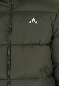 Oliven grøn pufferjakke med quiltet struktur, frontlynlås og hvid geometrisk logo på brystet.