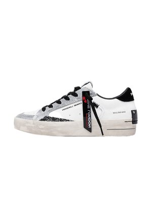 Sneaker bianca low-top con lacci neri, dettagli glitter argento, linguetta nera sul tallone e un'etichetta nera con la scritta "CRIME LONDON" attaccata ai lacci.