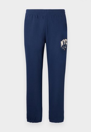 Marineblaue Sweatpants mit elastischem Bund, schmal zulaufenden Beinen und einem Logo mit "NYC" in heller Farbe auf dem linken Bein. Glatte Textur.
