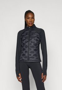 Parka preta com um design ajustado, apresentando um colarinho alto, fecho com zipper e painéis texturizados no peito e nas mangas.