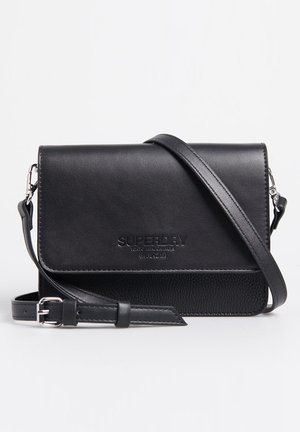 Zwarte leren crossbodytas met verstelbare riem, flapsluiting en gegraveerd "Superdry"-logo aan de voorkant.