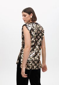 Sequin top featuring black base with circular metallic sequins in gold, bronze, and silver. Sleeveless design with a straight cut.