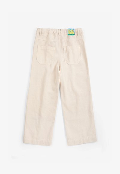 Pantalon beige pour tout-petit avec ceinture élastique, deux poches arrière et un petit patch logo coloré en haut au centre.