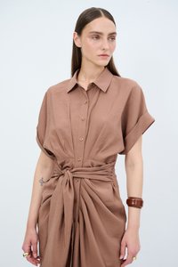 Abito button-up marrone realizzato in cotone. Presenta maniche corte ripiegate, una vita annodata e una gonna plissettata con bottoni decorativi in legno.