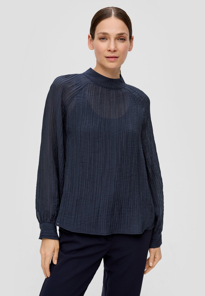 Donkerblauwe blouse met lange mouwen en een hoge halslijn, met textuur in de plooien en een relaxte pasvorm. Zacht, doorschijnend materiaal met een lichte glans.