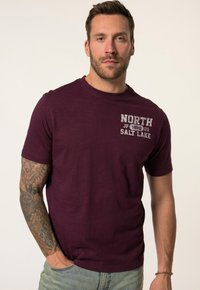 Burgundské tričko s krátkým rukávem a kulatým výstřihem, na kterém je bíle vytištěný text "NORTH JP 1880 US SALT LAKE." Hladká textura.