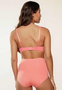 Roze beha en set met hoogzijdige onderbroek. Glad materiaal, verstelbare bandjes en haaksluiting. Geen zichtbare patronen of accenten.