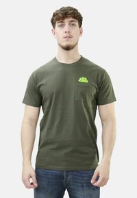 T-shirt in cotone verde oliva con scollatura rotonda e maniche corte. Presenta una tasca sul petto con un design grafico verde brillante.