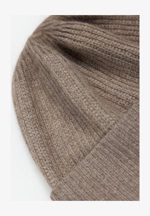 Weiche, gerippte Strickmütze aus hellbrauner Wolle mit umgeschlagenem Bündchen, in Nahaufnahme mit Detailansicht der Textur.