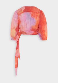 Blusa corta de manga corta con un patrón de acuarelas en tonos naranja, rosa y púrpura. Presenta un detalle de lazo en la cintura y un espalda ligeramente fruncida.