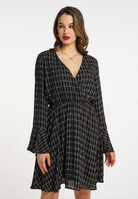 Rochie neagră cu model, cu mâneci lungi, decolteu în formă de V și talie elastică. Prezintă un imprimeu cu diamante și flori în nuanțe de aur și albastru.