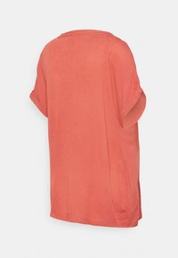 Camisa de manga curta, cor-de-pêssego, feita de tecido leve; apresenta um corte descontraído e um decote redondo com mangas dobradas.