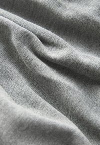 Tissu gris avec une surface lisse et légèrement texturée, présentant des plis subtils et une couleur uniforme. Idéal pour les vêtements ou l'ameublement.