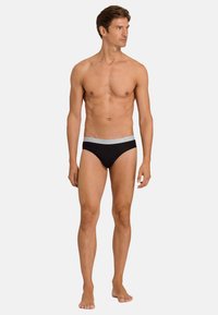 Černé pánské boxerky s šedým elastickým pasem s názvem značky. Měkká tkanina, přiléhavý střih a klasický design pro pohodlí.