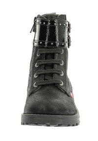 Botín negro de tobillo con superficie texturizada, que cuenta con una correa de charol brillante con tachuelas, parte delantera con cordones y suela de goma resistente.