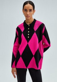 Maglione a maglia argyle rosa e nero con colletto, caratterizzato da una fila di bottoni dorati sul davanti e maniche lunghe. Texture liscia.