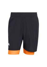 Shorts de sport noirs avec une ceinture élastique et un ourlet orange. Présentent un tissu texturé et un logo blanc sur le côté gauche.