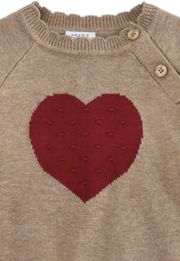 Maglione beige in maglia con un motivo a cuore rosso testurizzato al centro, con un collo arricciato e due bottoni in legno su una spalla.