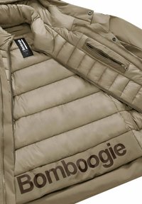 Beżowa kurtka ocieplana od środka z poziomymi przeszyciami, z czarną metką i dużym brązowym logo "Bomboogie" na podszewce.