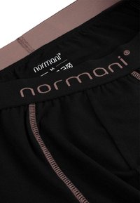 Schwarze Boxershorts mit einem weichen, elastischen Bund, der ein kontrastierendes pinkes Logo trägt. Mit pinken Nähten entlang der Kanten genäht.