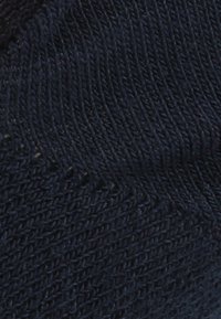 Granatowy dzianiny z teksturowanym, lekko nierównym wzorem, z ukośnymi liniami i miękkim, elastycznym wyglądem.