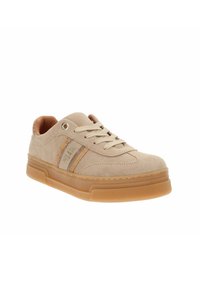 Beżowe zamszowe sneakersy z brązową gumową podeszwą, z tonowymi sznurówkami, akcentującymi paskami i okrągłym otworem na boku.